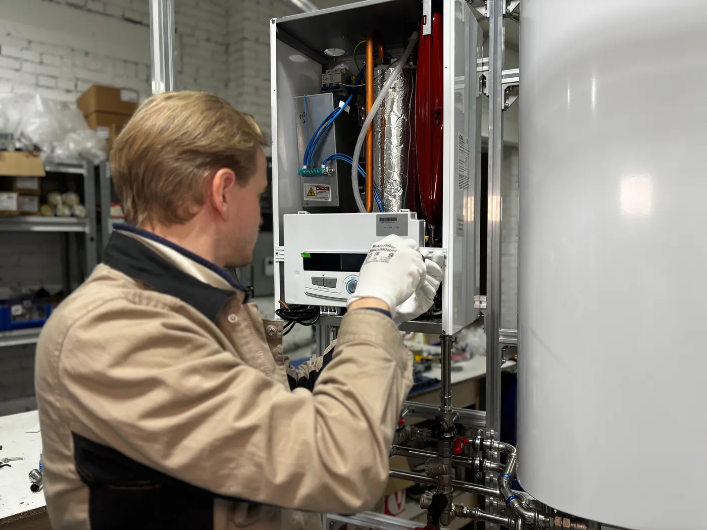 Techniker prüft eine geöffnete Heizungsanlage in der Werkstatt – Symbolfoto