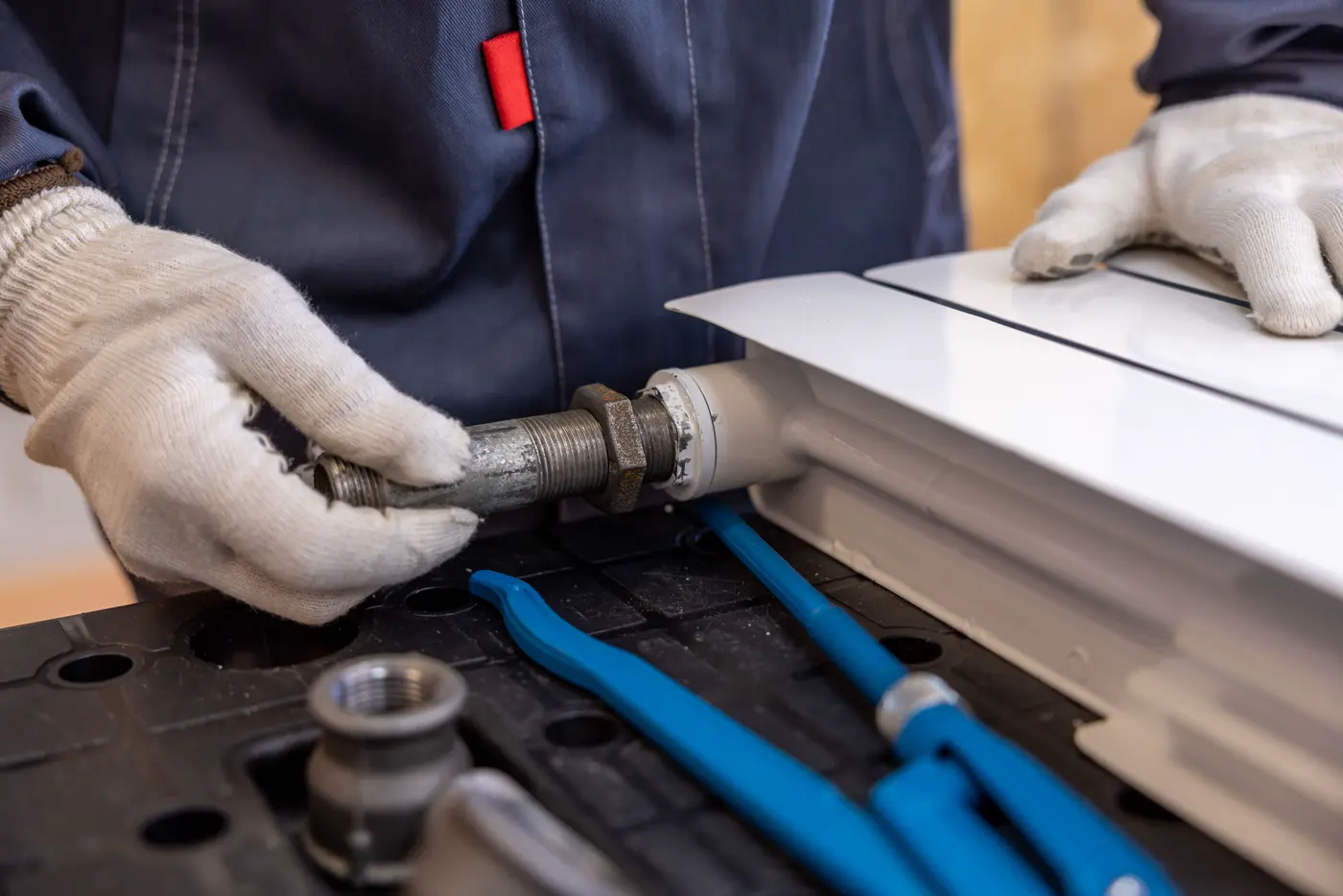 Installateur montiert eine Heizungsleitung mit professionellem Werkzeug
